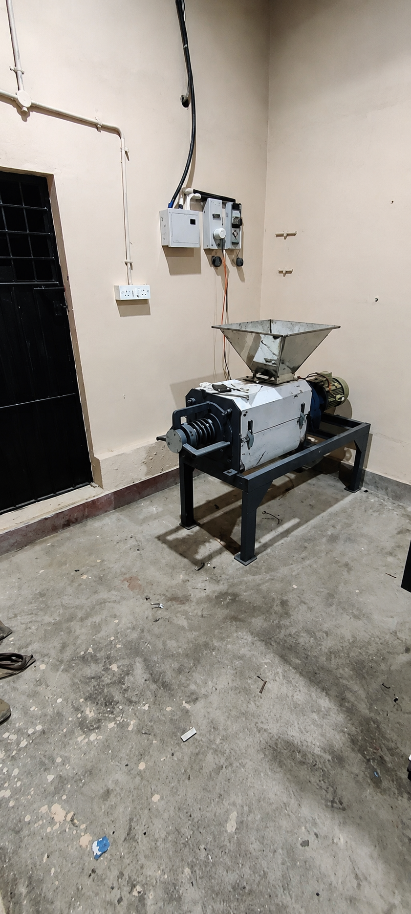 Composting machine in a clean, indoor space, showcasing its hopper and motor setup for organic waste processing.